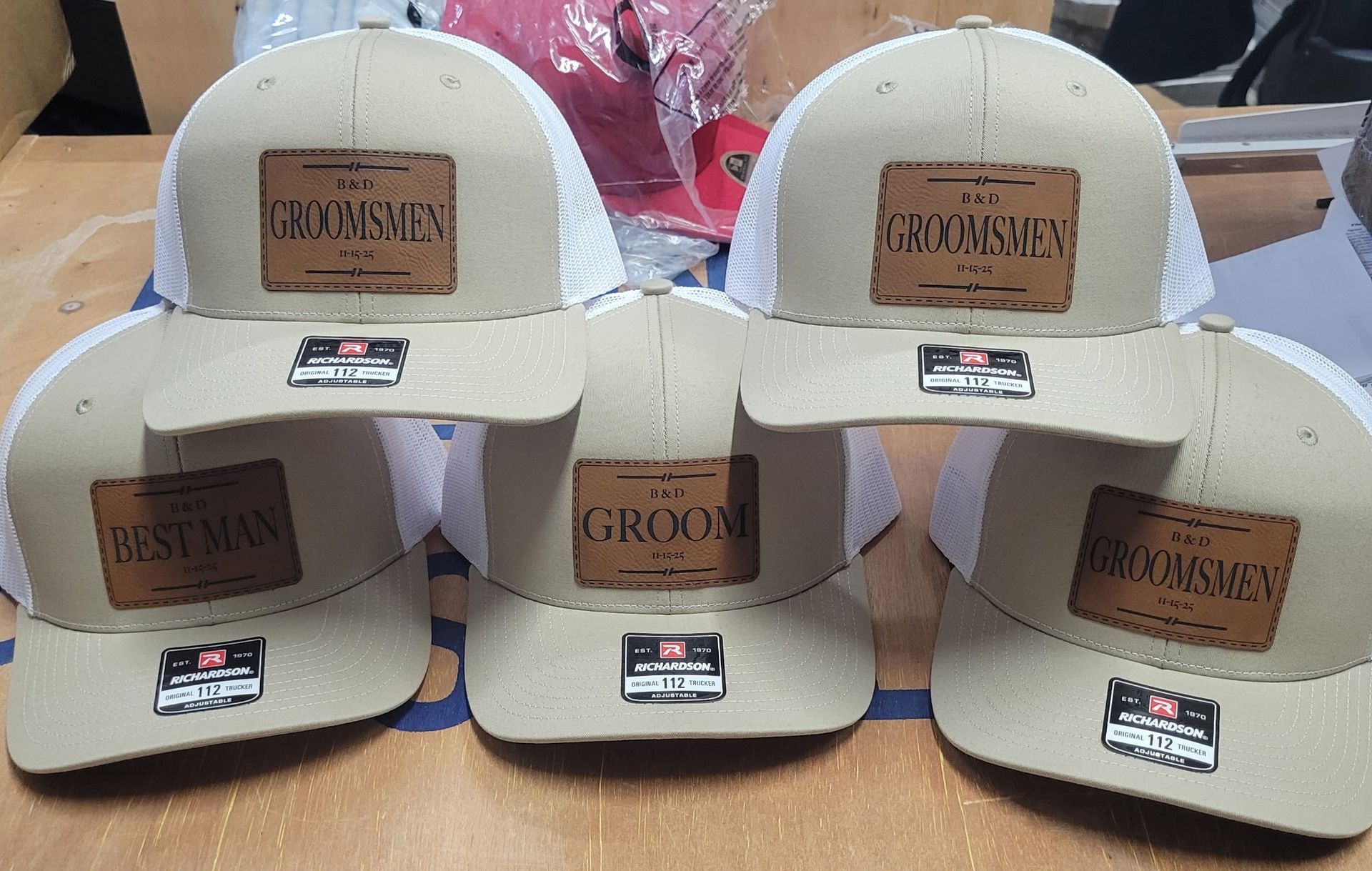 A group of hats with leather patches on them are sitting on a table.