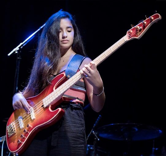 Music academy student playing bass on stage