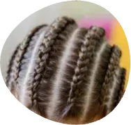 Close-up of neatly braided hair with dark and light strands against a blurred pink and yellow background
