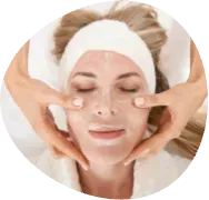 Spa therapist massaging a woman’s face with cream and a white headband