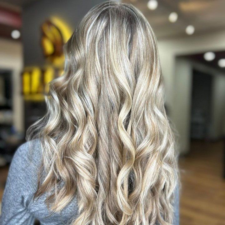 Wavy platinum blonde hair viewed from behind in a salon