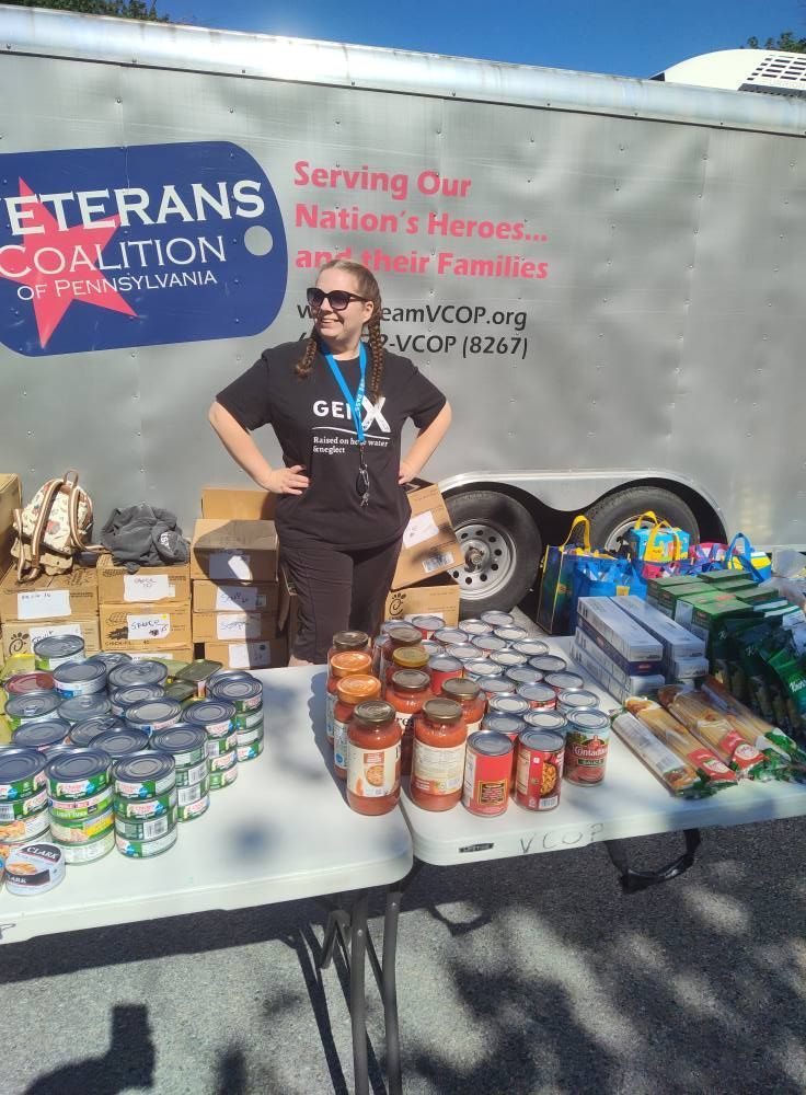 Woman standing at table of canned goods with 