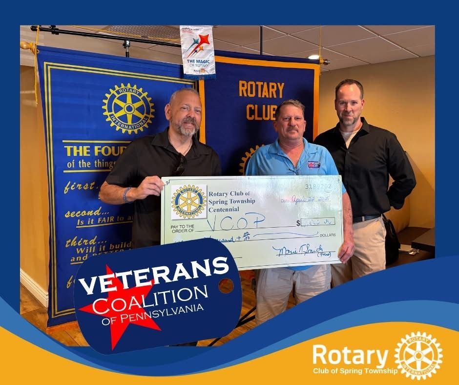Three men holding a check from Rotary Club to Veterans Coalition of PA. Blue banner backdrop.