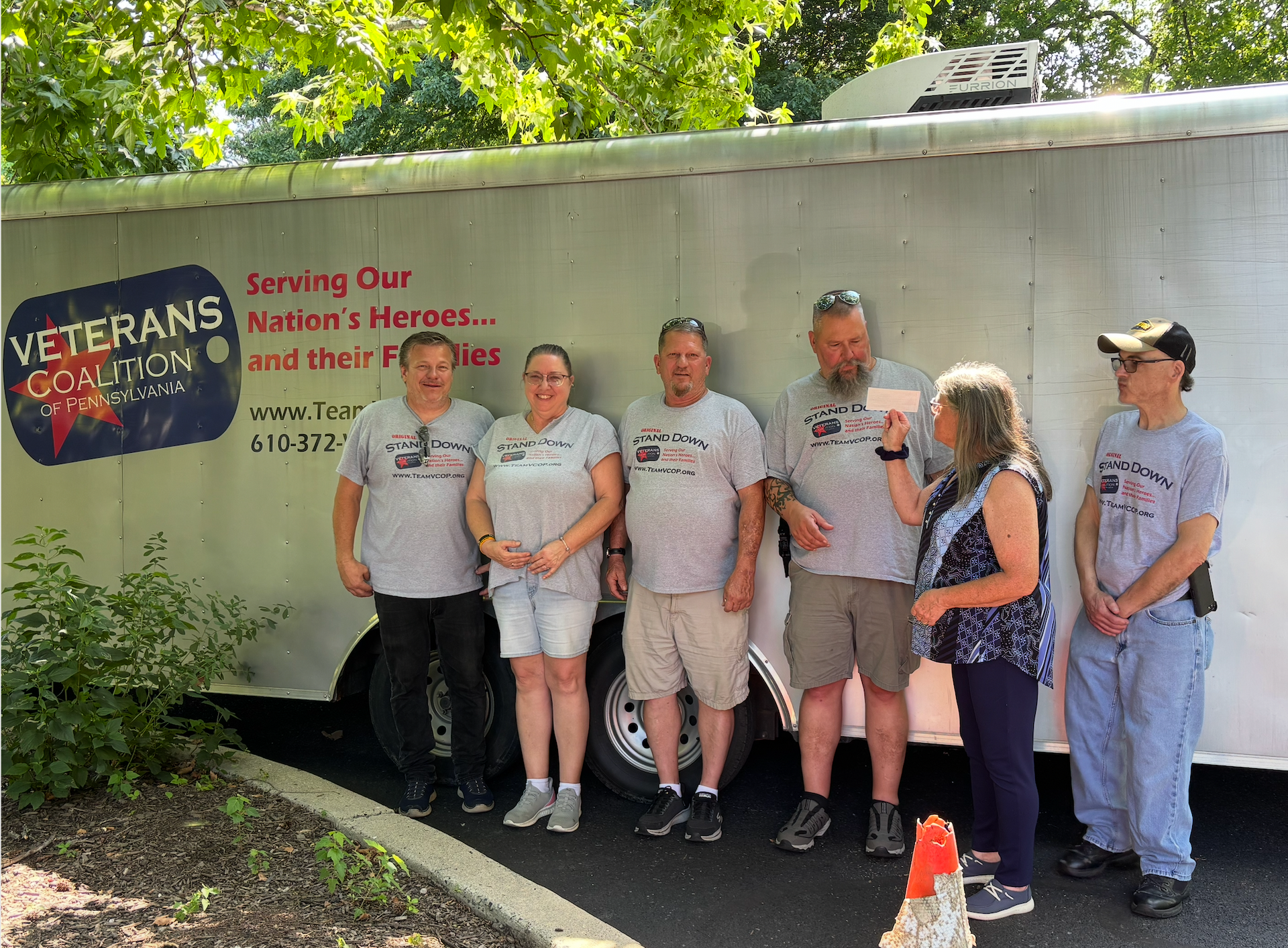 Six people in front of a trailer with 