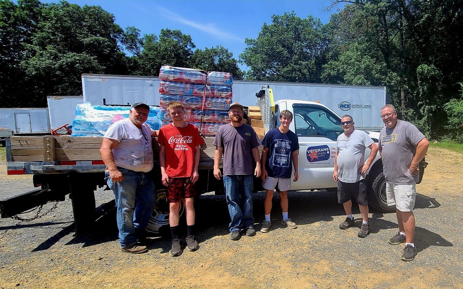 People beside truck loaded with bottled water for distribution.