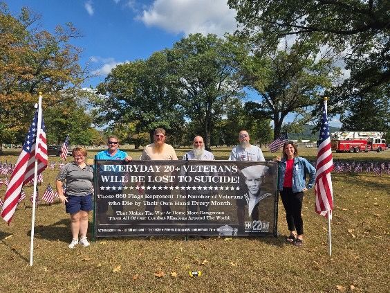 Group with sign, flags, and headstone markers, reading 