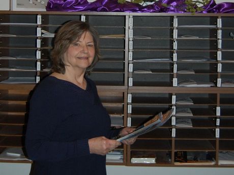 A woman holding a piece of paper in front of a sign that says 