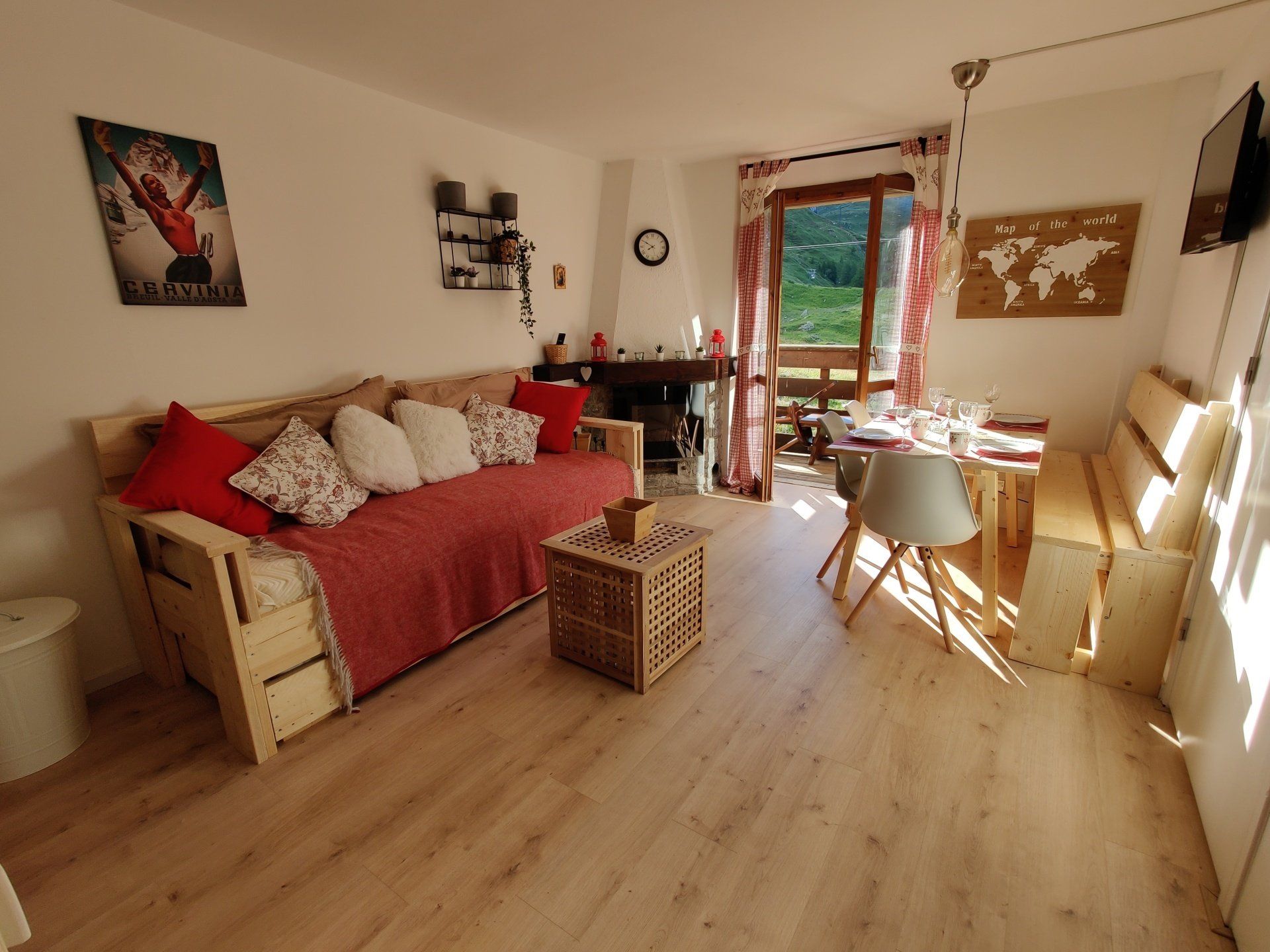 Overview picture of the living room seeing a sofa bed, a set table, electric fireplace and Mountain View