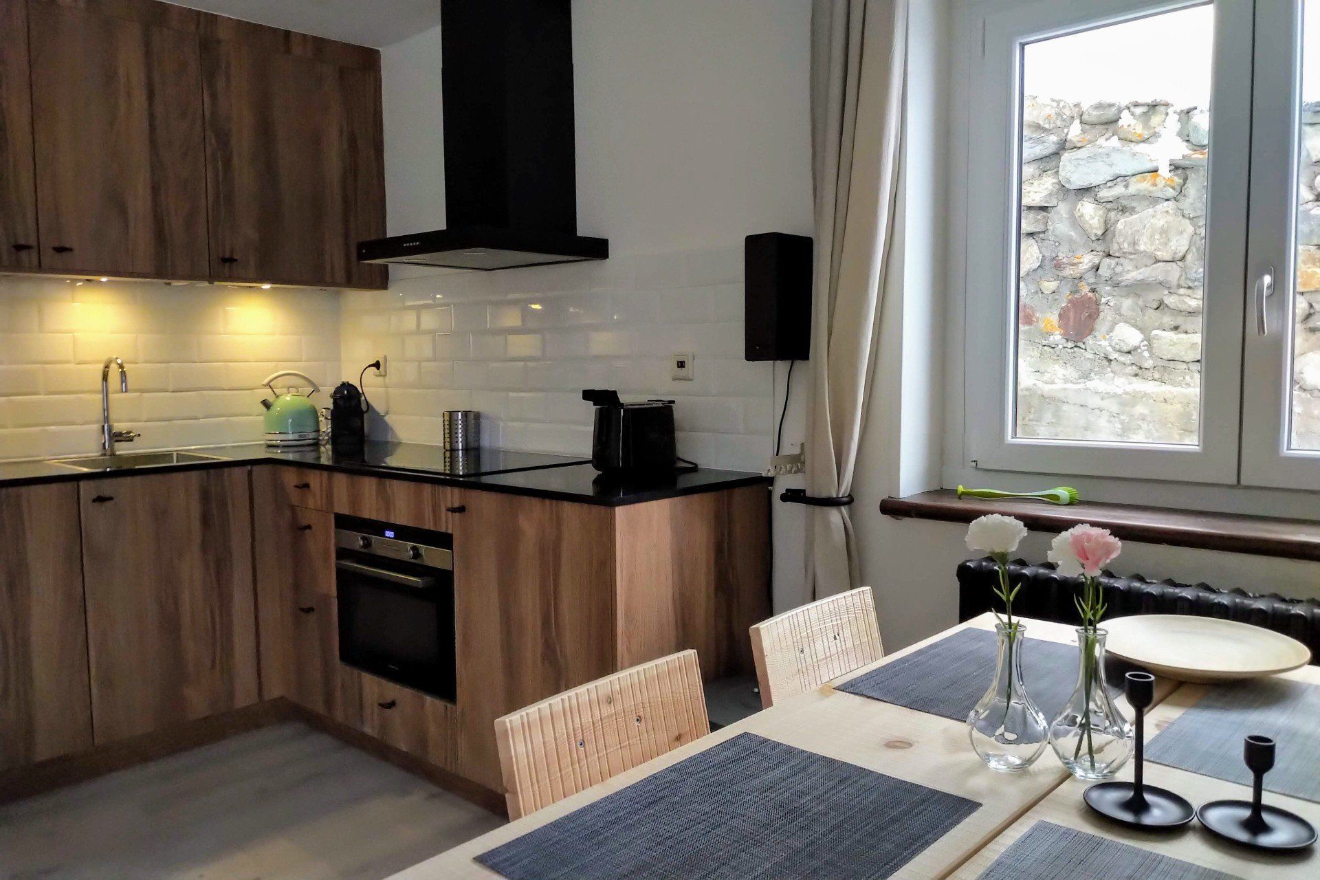 Set table in the living room with a modern kitchen behind it