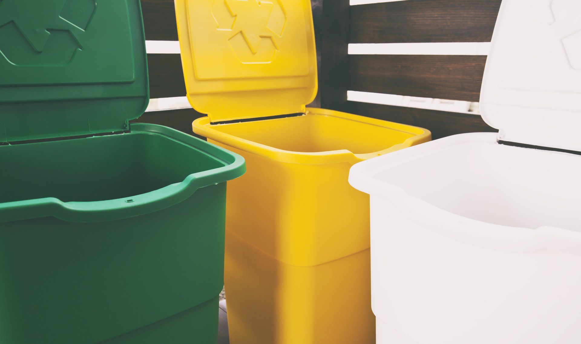 Tres botes de basura de colores para clasificar la basura para vidrio y papel de plástico