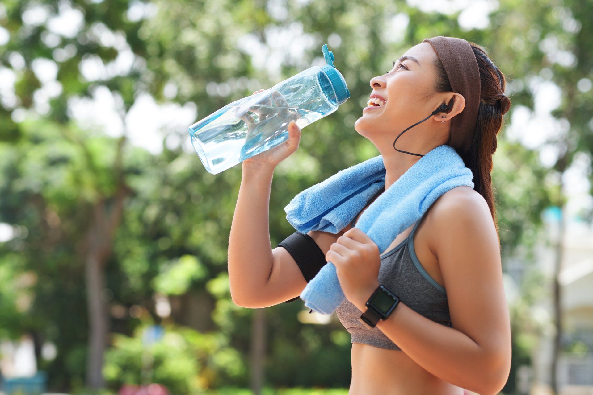 Deportista feliz agua potable en el parque Deportista feliz agua potable en el parque