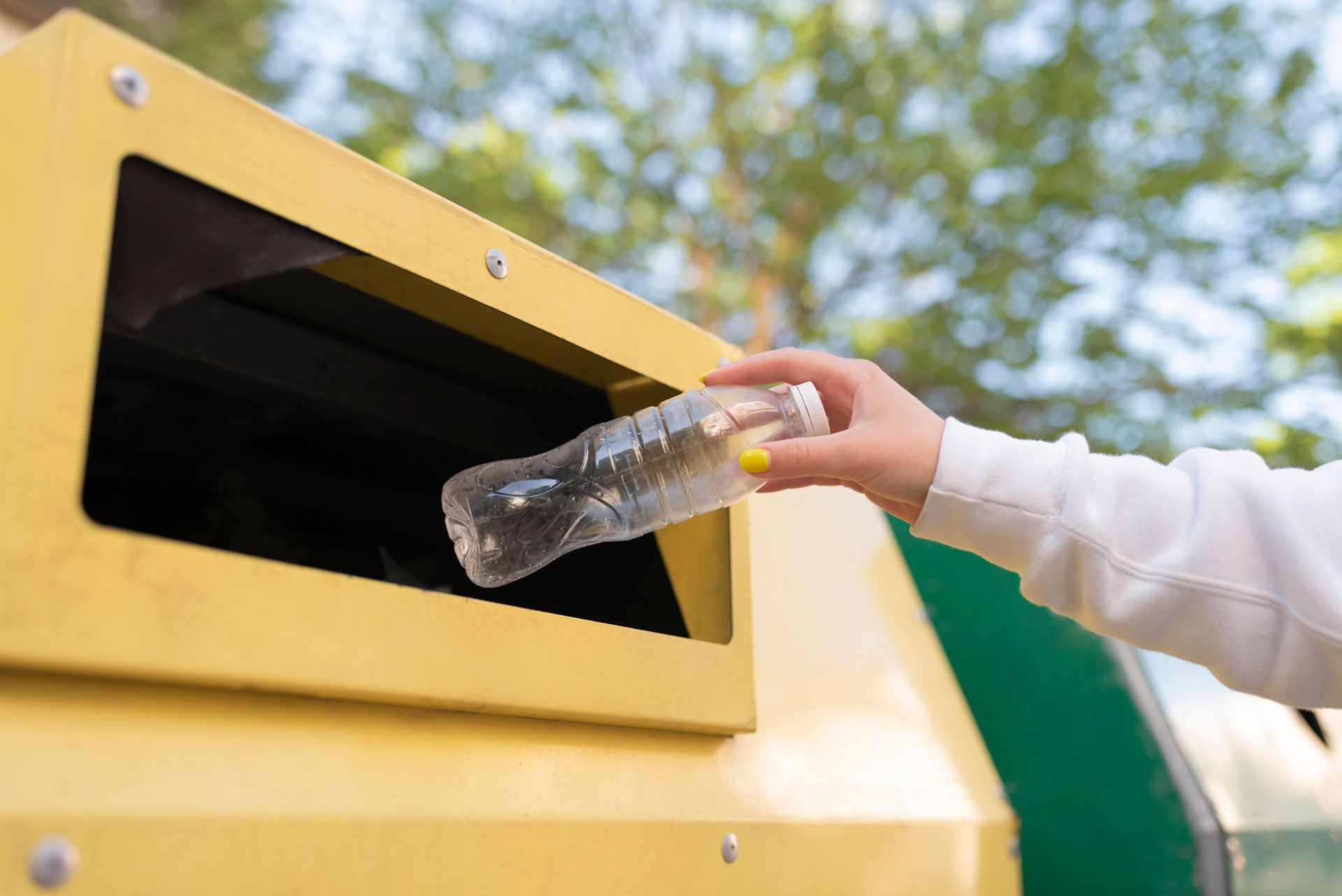 Mujer tirando una botella en un servicio de recolección de basura sostenible Mujer tirando una botella en un servicio de recolección de basura sostenible