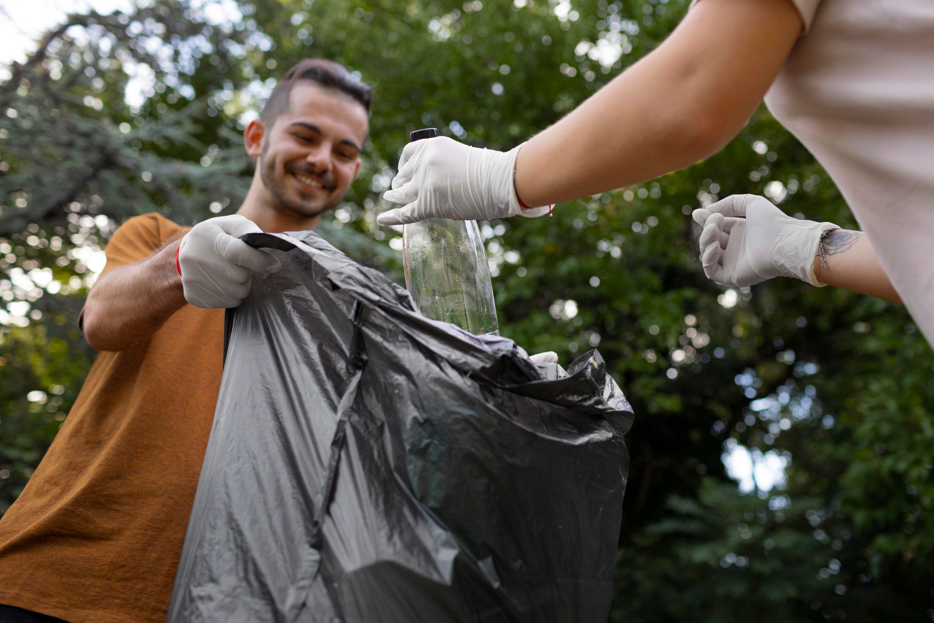 personas del servicio de recolección de basura recogiendo botellas pet 