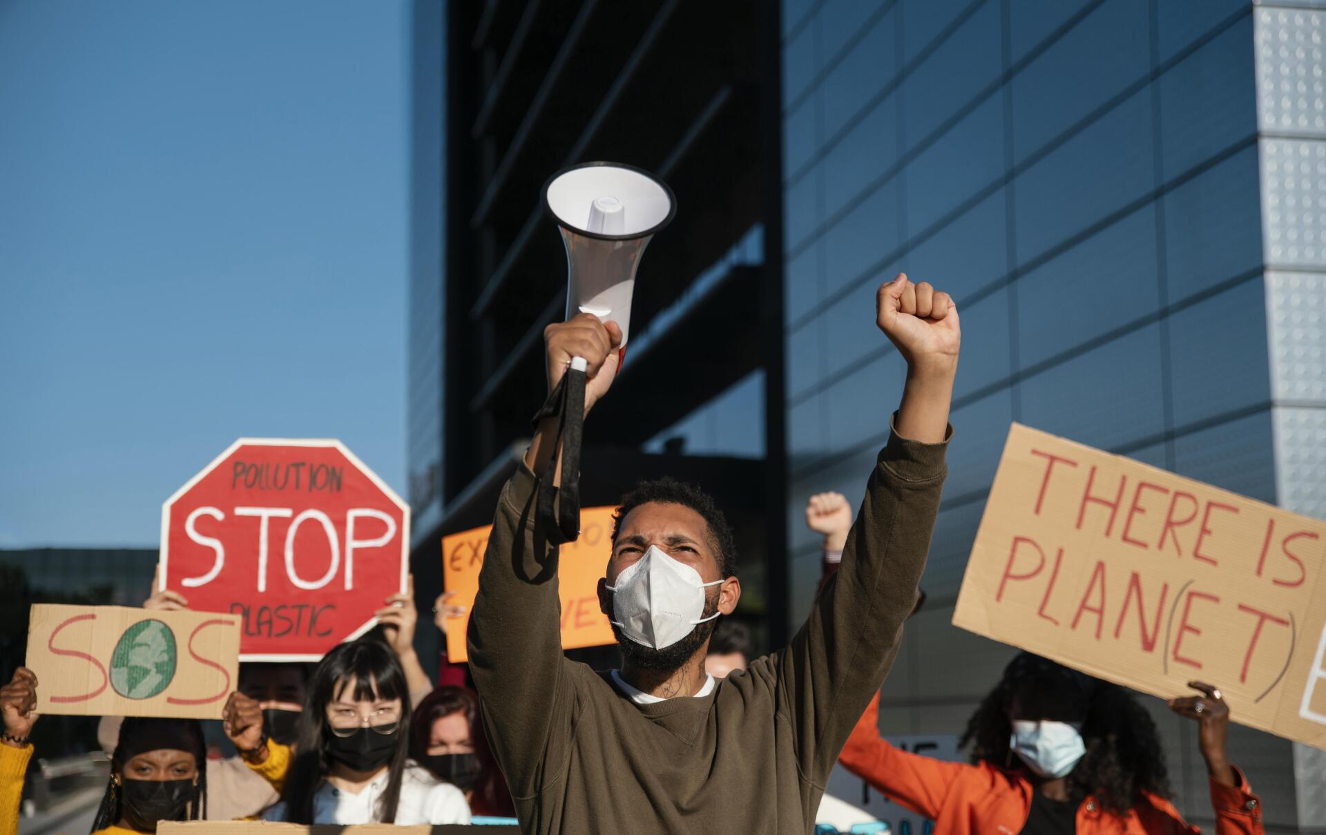 Personas con máscaras en protesta ambiental Personas con máscaras en protesta ambiental