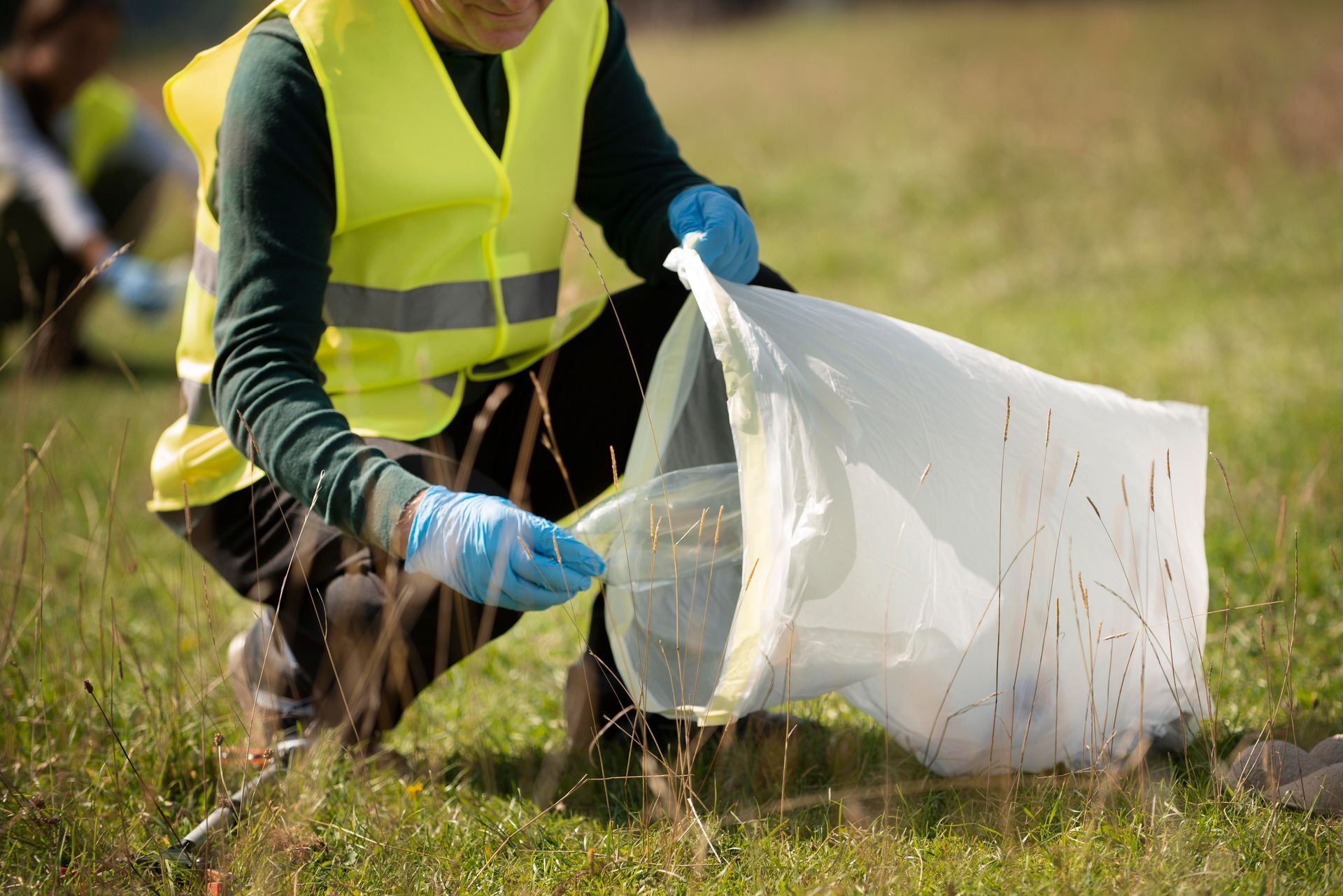 persona recogiendo residuos ´plásticos  en un parque 