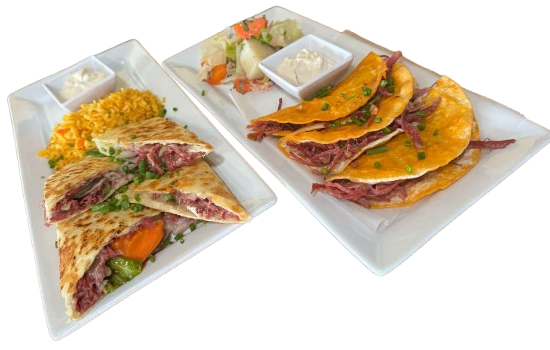 Two plated taco meals with rice, salsa, and avocado on white trays