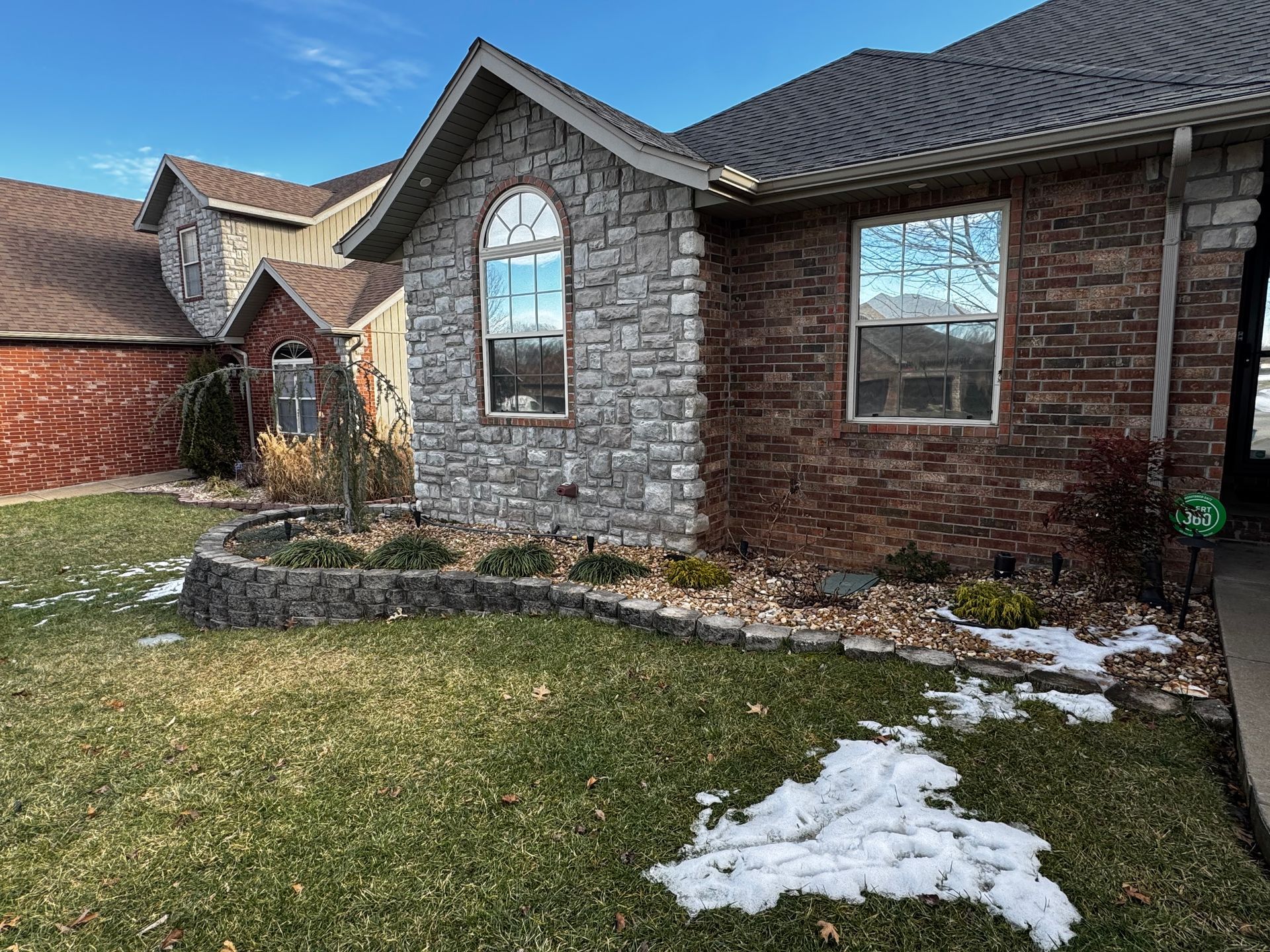 A brick house with a stone facade and a large window