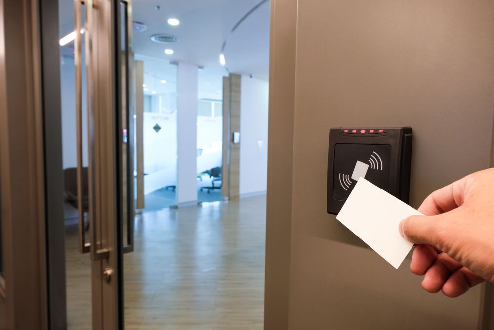 Hand Holding Access Card Near Door Security Card Reader, Inside Office Hallway — North East Locksmiths in Wodonga, VIC
