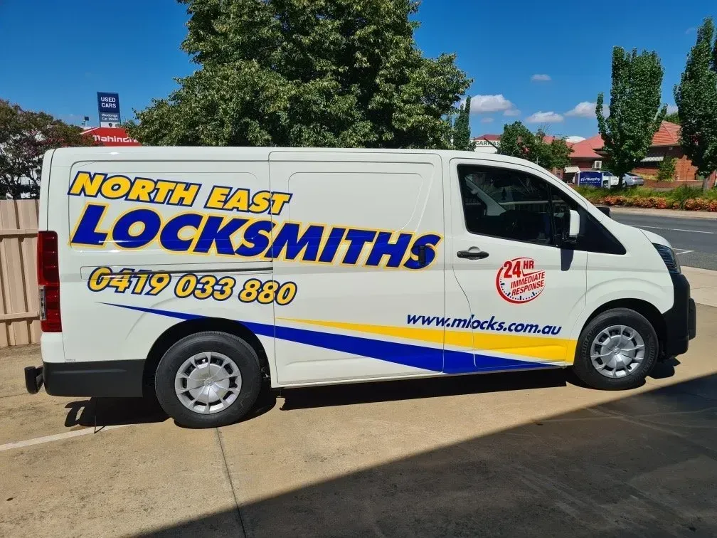 White Van With North East Locksmiths Logo and Phone Number Parked Outdoors — North East Locksmiths in Wodonga, VIC