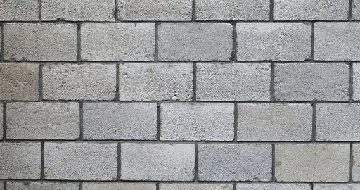 Gray cinder block wall with staggered rows and a rough texture