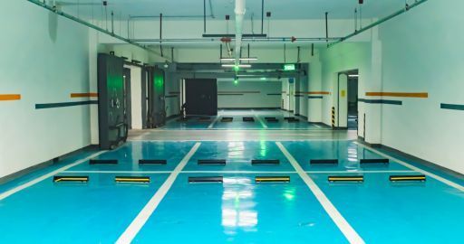 Bright indoor swimming pool with turquoise lanes and lane markers, viewed from one end
