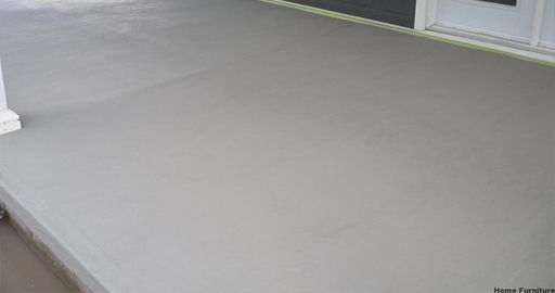 Empty gray concrete patio beside a white wall and steps