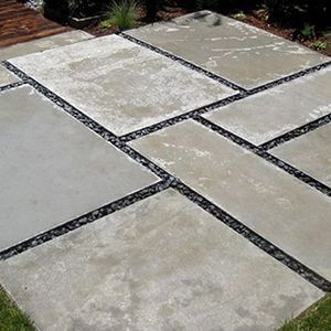 Patterned stone patio with large light-gray pavers and dark gravel joints