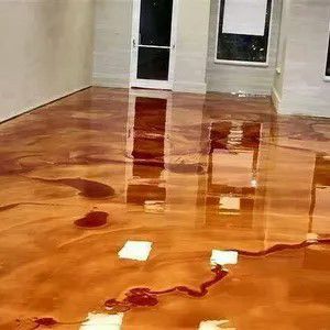 Flooded room with glossy wooden floor and water pooling around a white door and window reflections