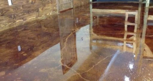 Dim interior with glossy brown marble walls and floor, reflecting a wooden chair and doorway.