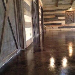 Rustic room with wood plank walls and a glossy dark floor reflecting light.
