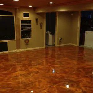 Empty room with glossy orange wood floor, recessed lights, and wall-mounted TV alcove.