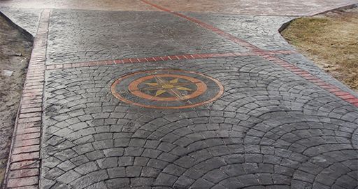 Cobblestone path with a painted circular no-parking symbol and red boundary line