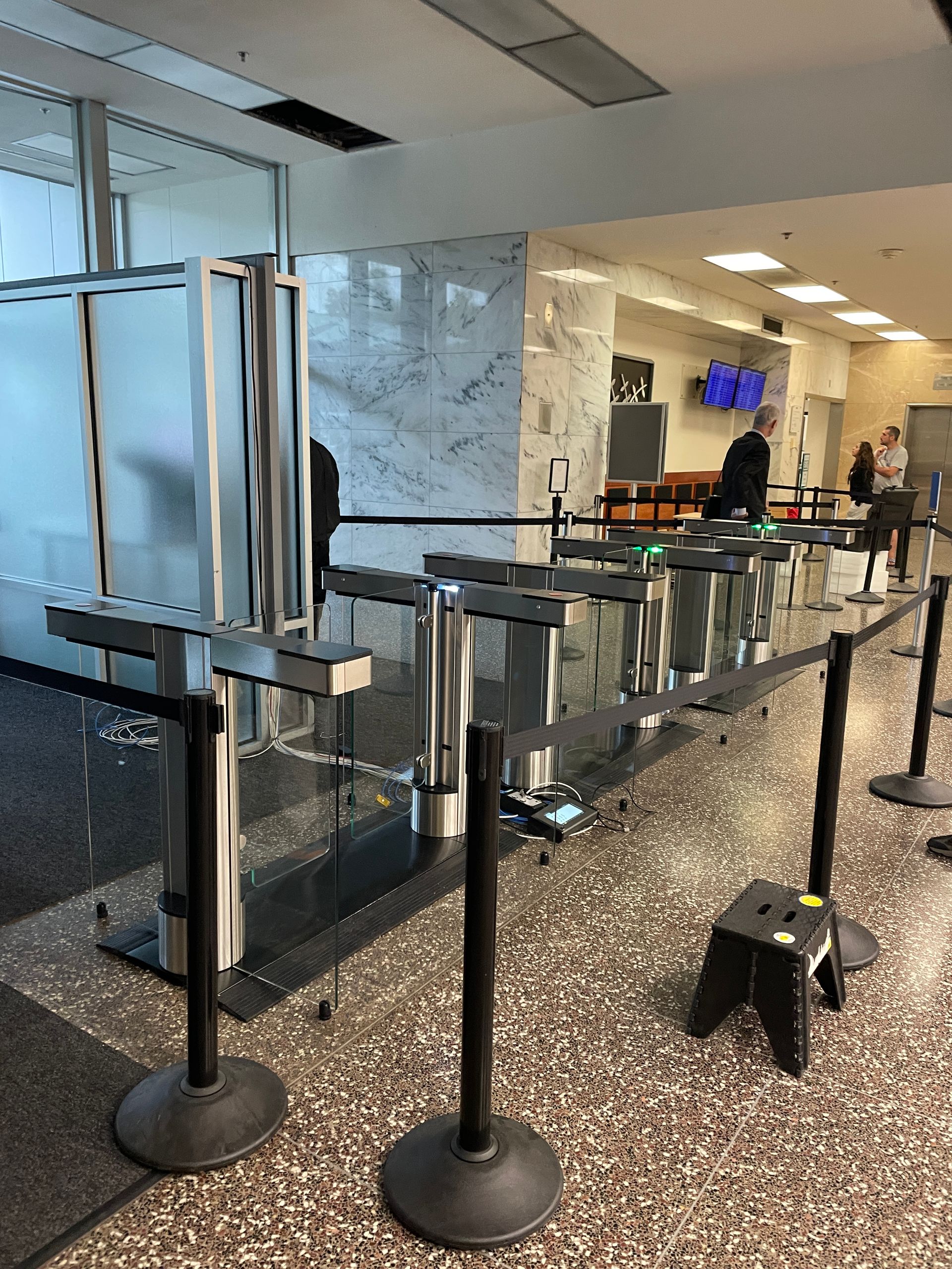 Hallway with security queue. Metal stanchions with black belts. 