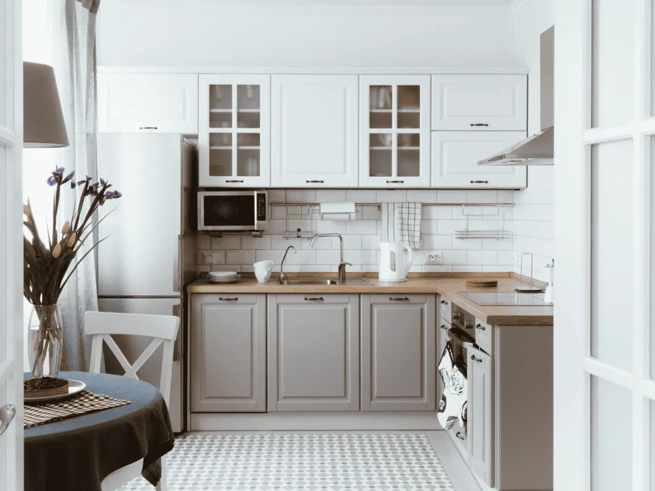 A kitchen with white cabinets , a refrigerator , a sink , and a table. A kitchen with white cabinets , a refrigerator , a sink , and a table.