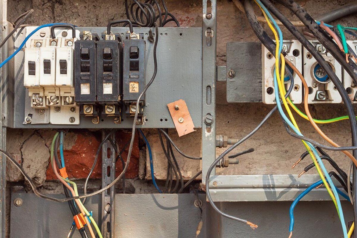 A very messy electrical box with a lot of wires coming out of it A very messy electrical box with a lot of wires coming out of it