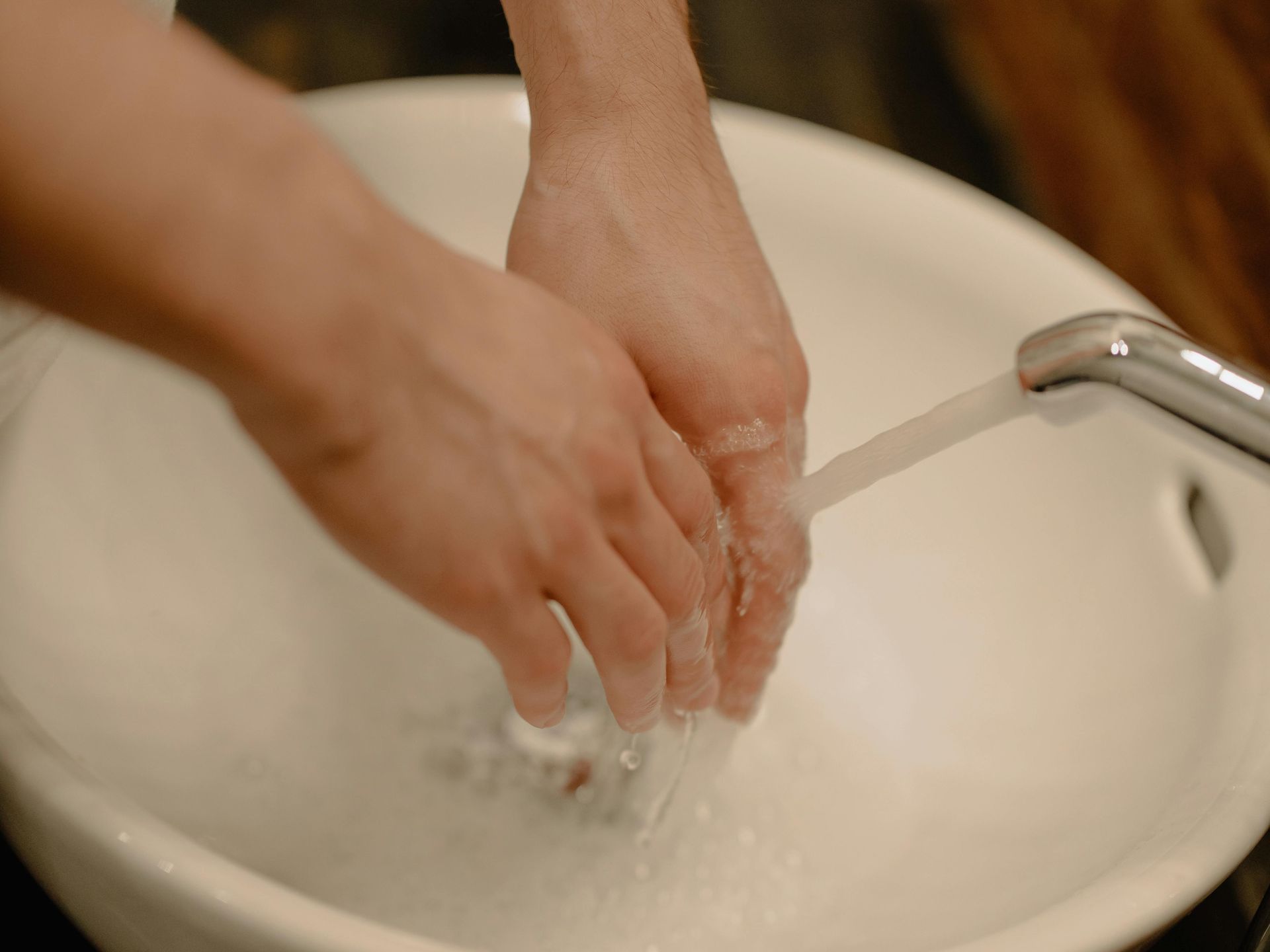 A person is washing their hands in a sink.