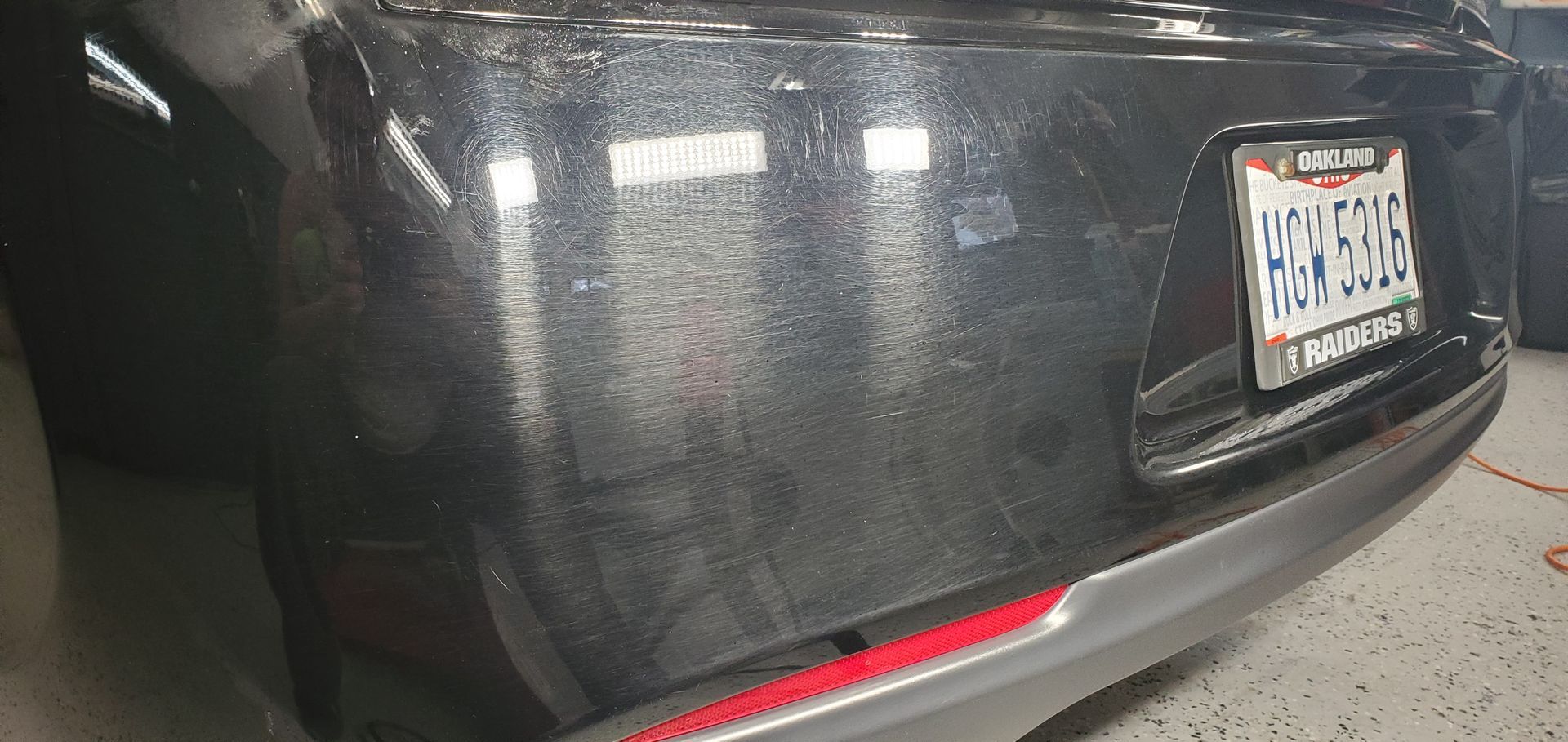 Rear view of a dark gray sedan with a Florida license plate in a garage.