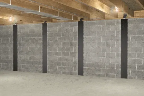Gray concrete block basement wall reinforced with several evenly spaced vertical carbon fiber strips.