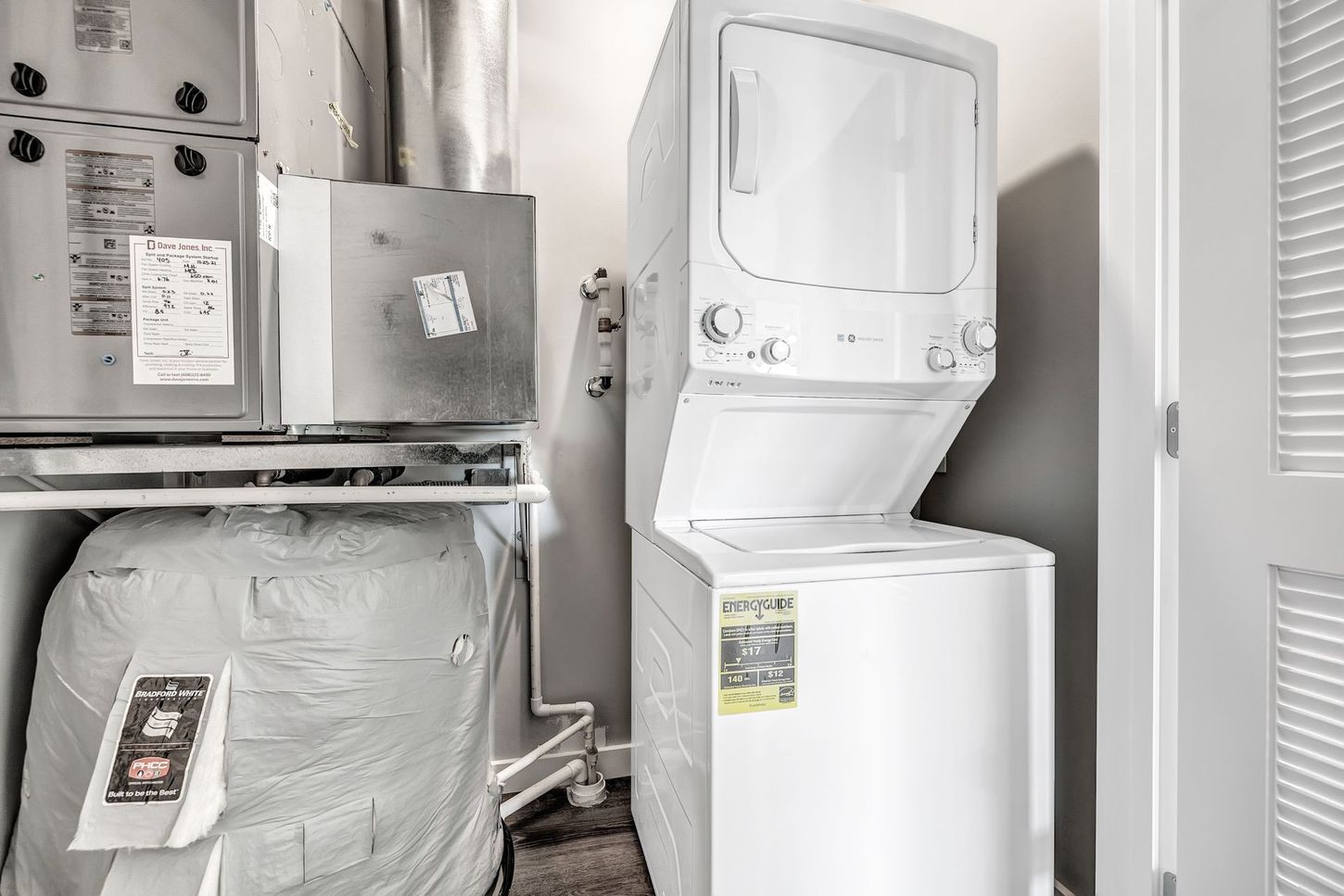 A washer and dryer are stacked on top of each other in a laundry room.