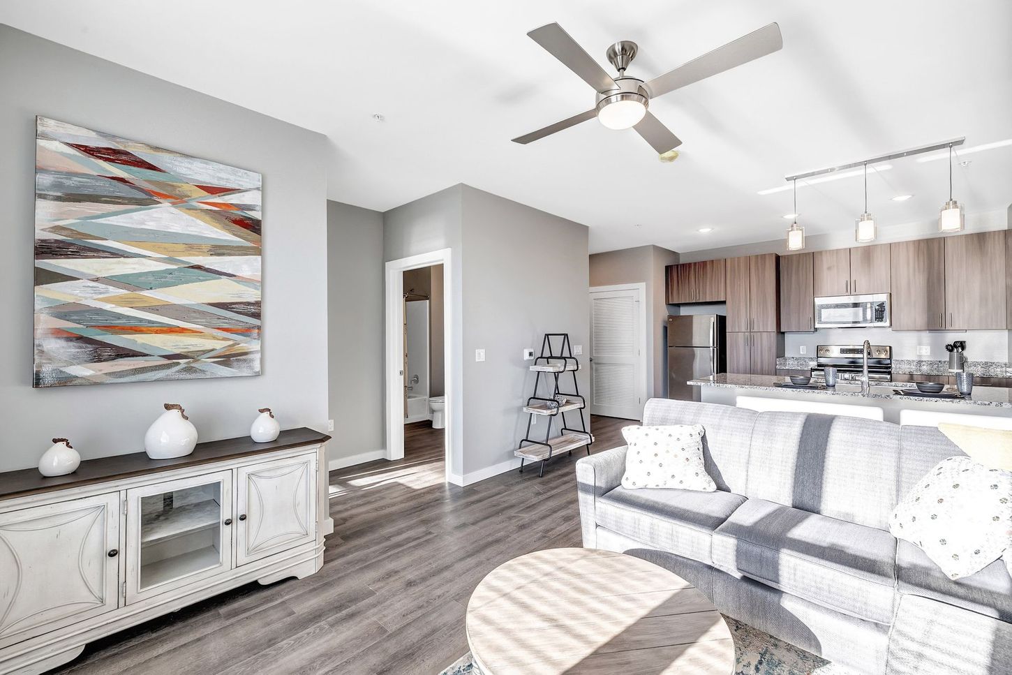 A living room with a couch , table , and ceiling fan.
