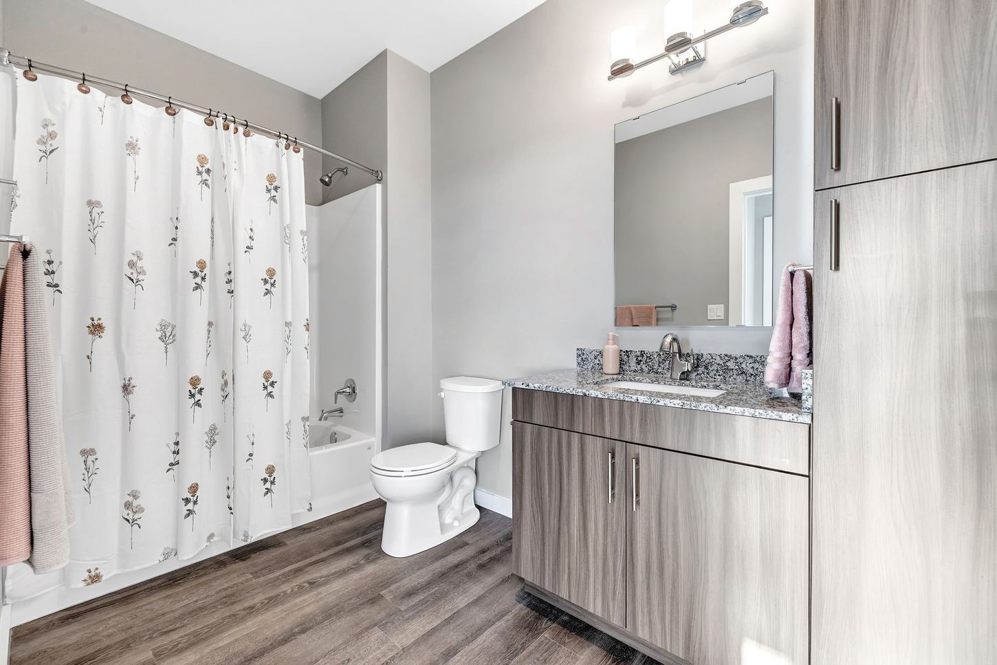 A bathroom with a toilet , sink , and shower curtain.
