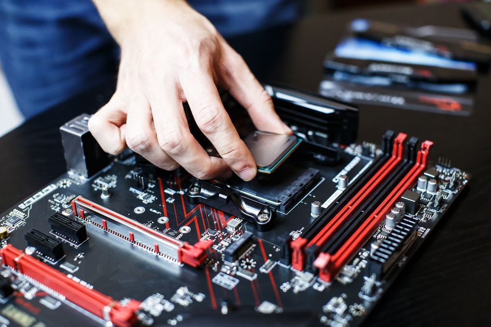 A Person Is Installing A Cpu On A Motherboard — Dateline Computers Authorised Jaycar Reseller In Bowen, QLD