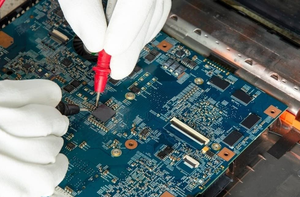 A Person Is Working On A Motherboard With A Multimeter — Dateline Computers Authorised Jaycar Reseller In Cannonvale, QLD