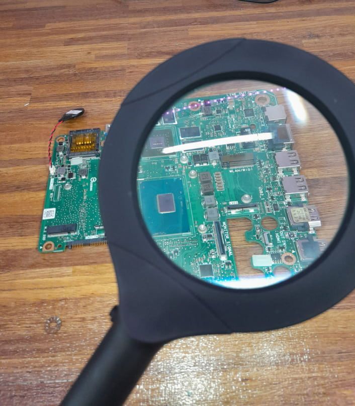 A Magnifying Glass Is Being Used To Look At A Motherboard — Dateline Computers Authorised Jaycar Reseller In Cannonvale, QLD