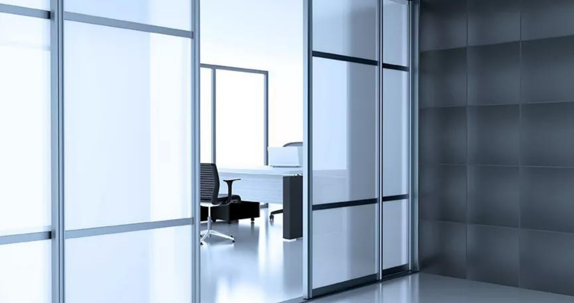 Interno di un ufficio con pareti in vetro e una scrivania visibile sullo sfondo.