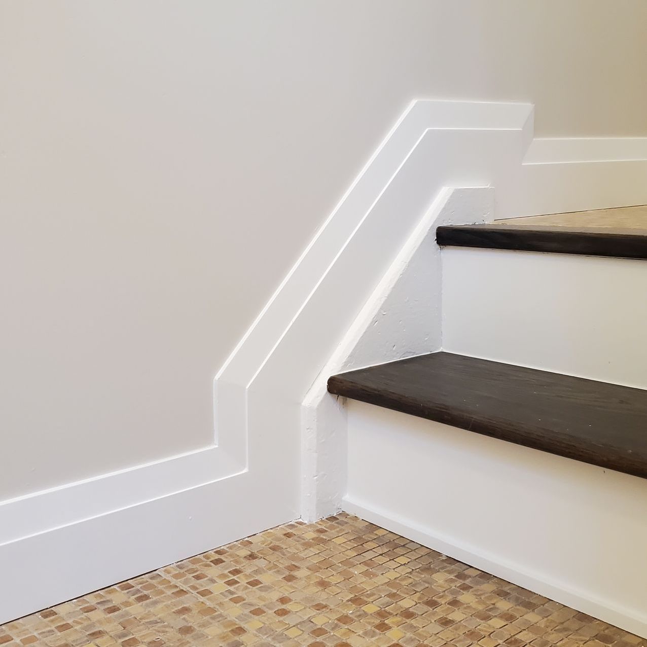Staircase with dark wood steps and white trim
