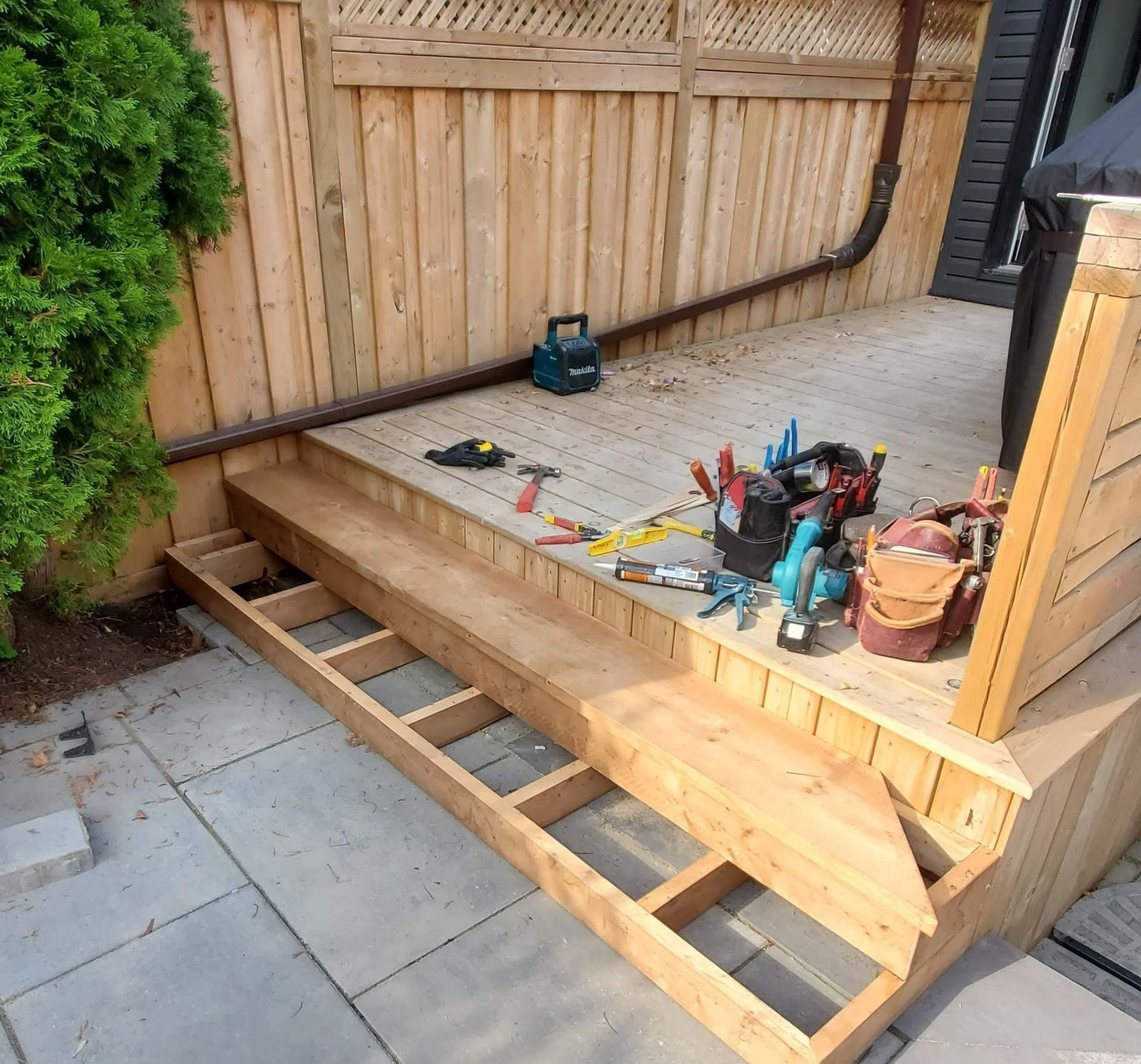 A wooden deck is being built with tools on it