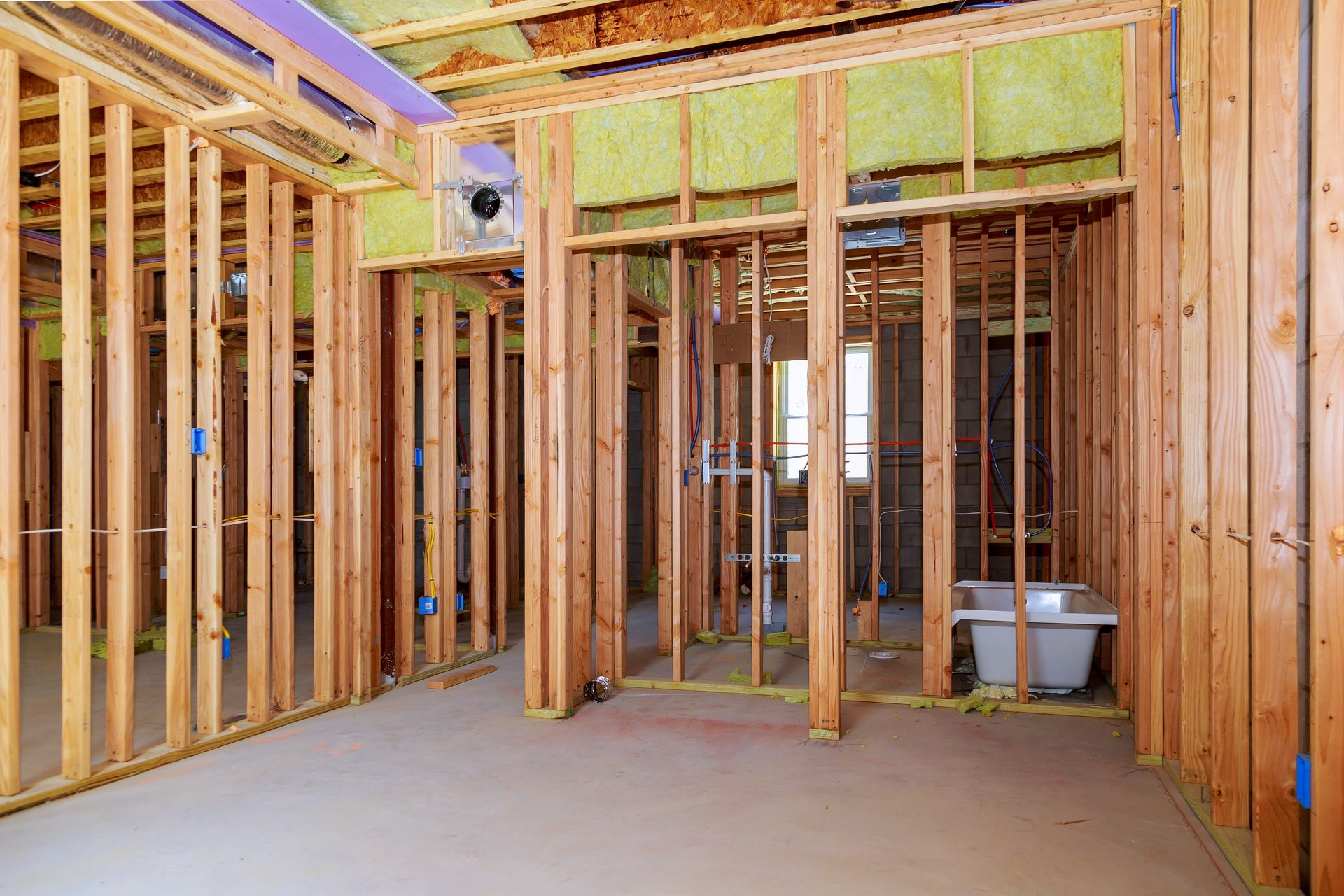 House under construction with wooden framing and exposed insulation