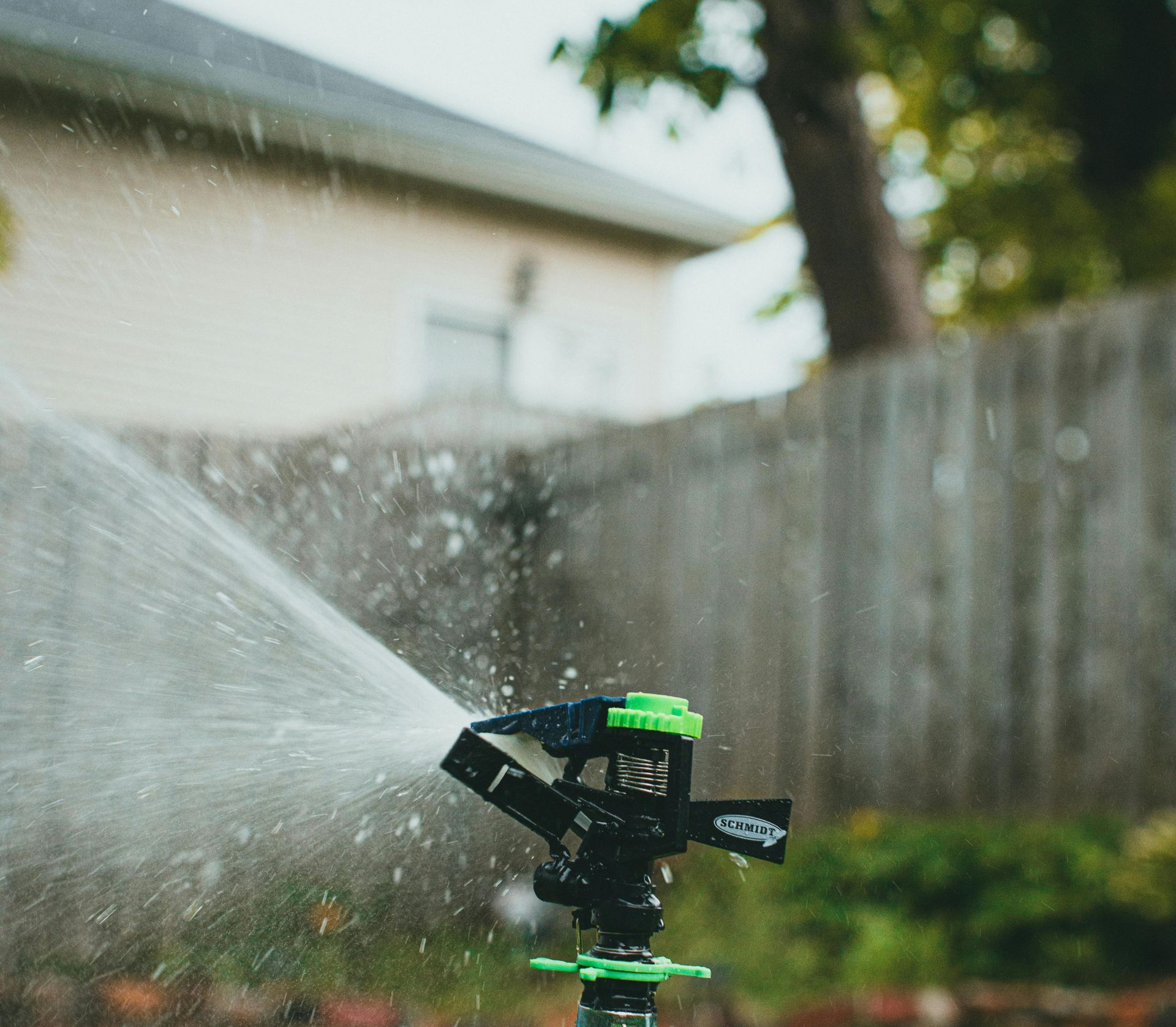 A man is using a high pressure washer to clean a patio.
