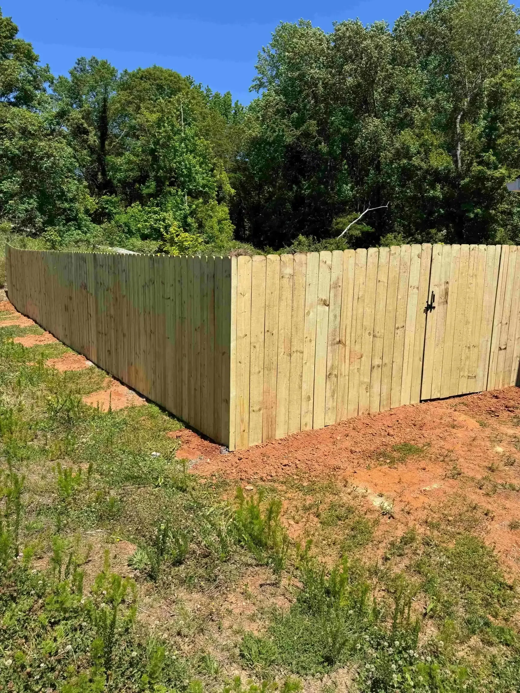 wood privacy fence with walk gate on sloped ground in Mauldin SC installed by True North Handyman